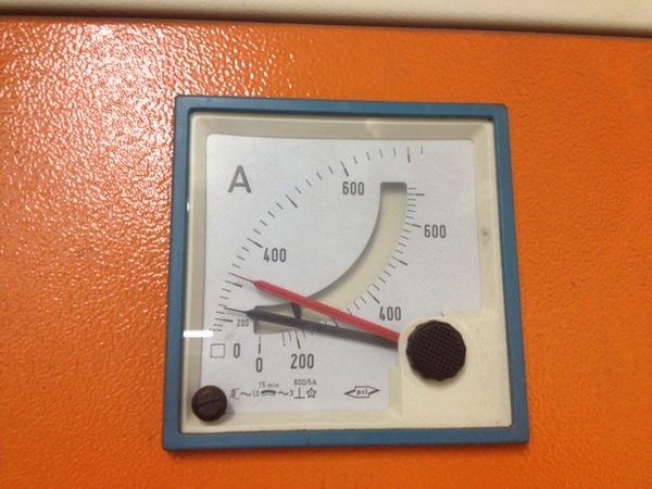 An analogue ammeter on an orange board
