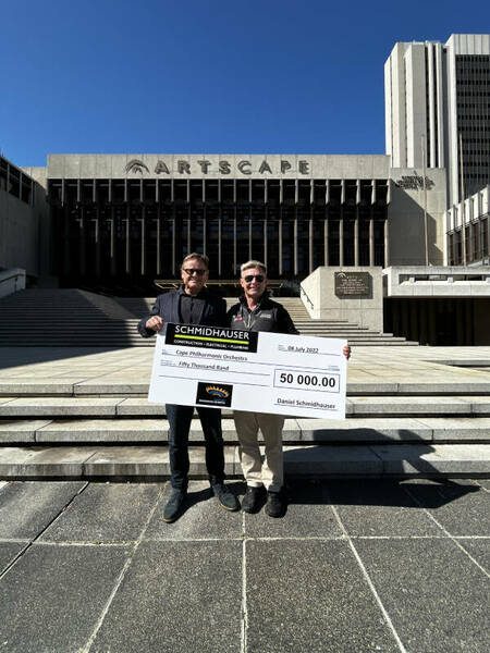 Daniel Schmidhauser handing over a cheque outside Artscape