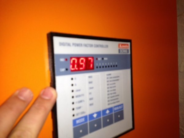 A digital power factor controller reading 0.97