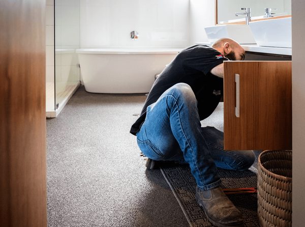 Schmidhauser plumber working under a basin
